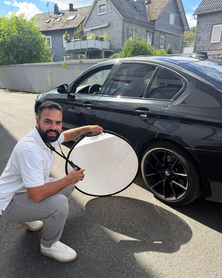Velit Bilek bei der Fotodokumentation eines Fahrzeugschadens mit Reflektor in Siegen